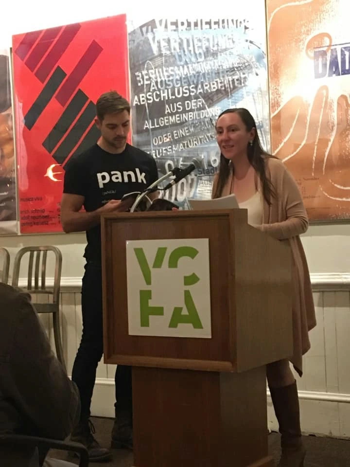 Dr. Darling reading at a VCFA podium